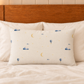 Moonrise filled lumbar cushion with printed front on plain ivory bedding.
